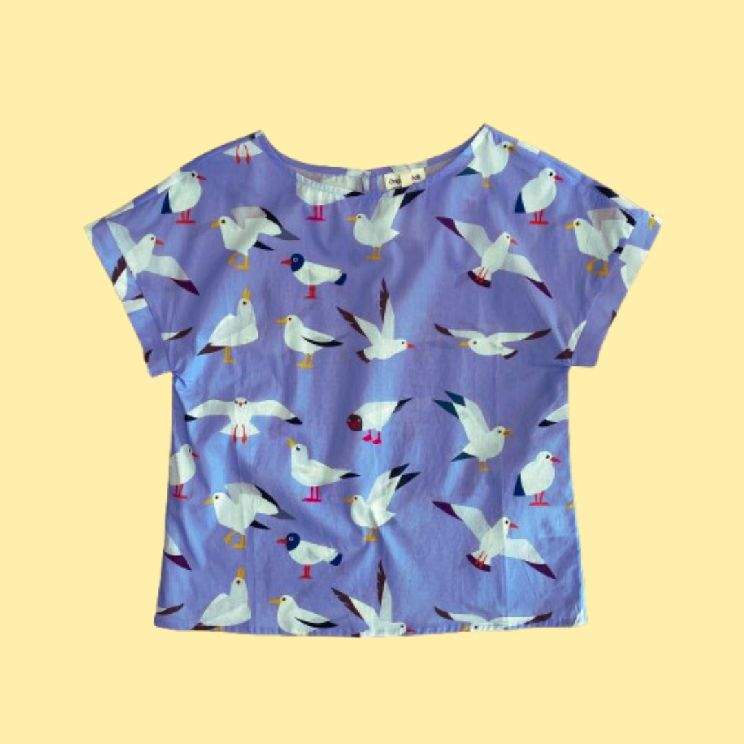 Flat lay of Origami Doll Freya Seagull Top. The top features seagulls in various postures.