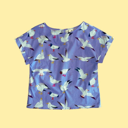 Flat lay of Origami Doll Freya Seagull Top. The top features seagulls in various postures.