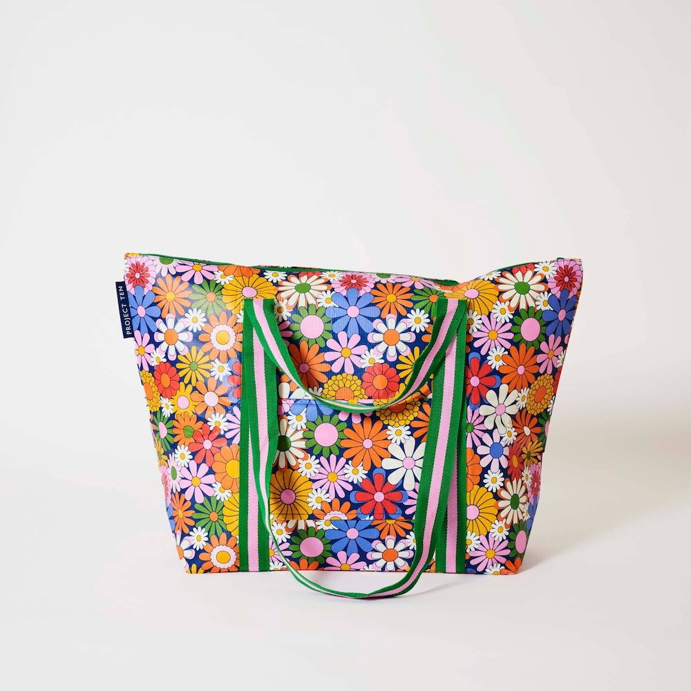 Project Ten Coastal Floral Medium Zip Up Tote - A large tote bag featuring a vibrant, multicoloured daisy floral print, with green and light pink striped handles, photographed against a clean white background.