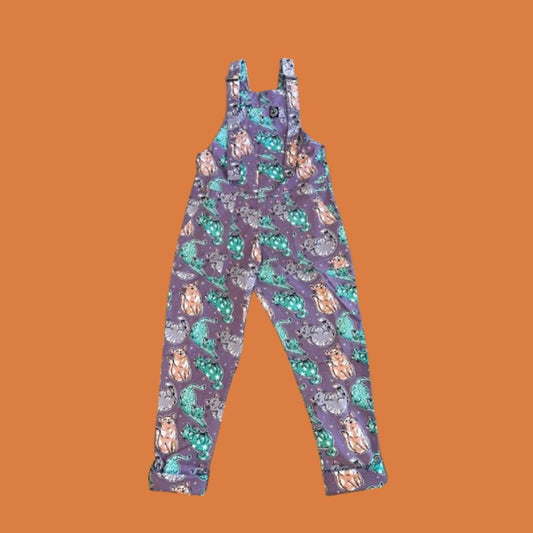 Purple overalls with cats pattern on an orange background
