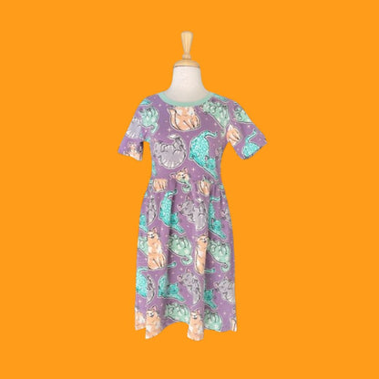 Jersey shirt dress in lilac purple with cat illustrations on a mannequin on an orange background