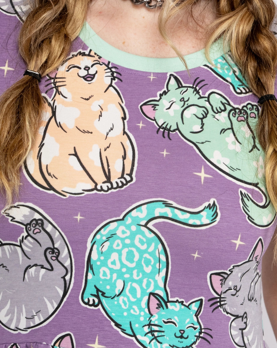 close up of the shirt dress with cat illustrations on a purple background