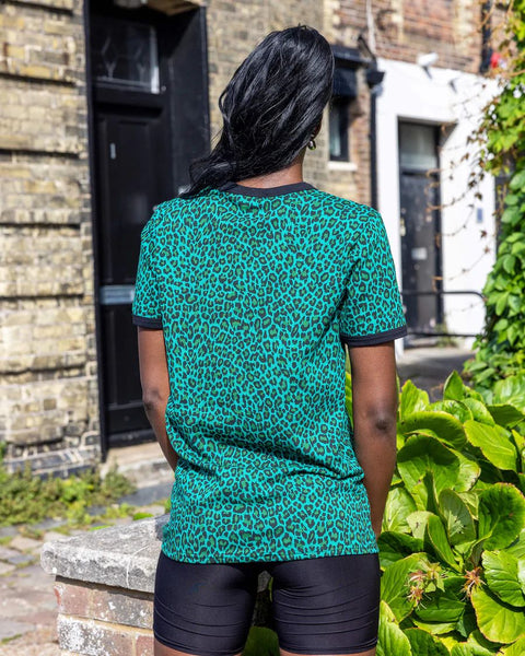 Back view of Model wearing Run and Fly Leopard Tee Shirt in Teal and paired with black shorts.