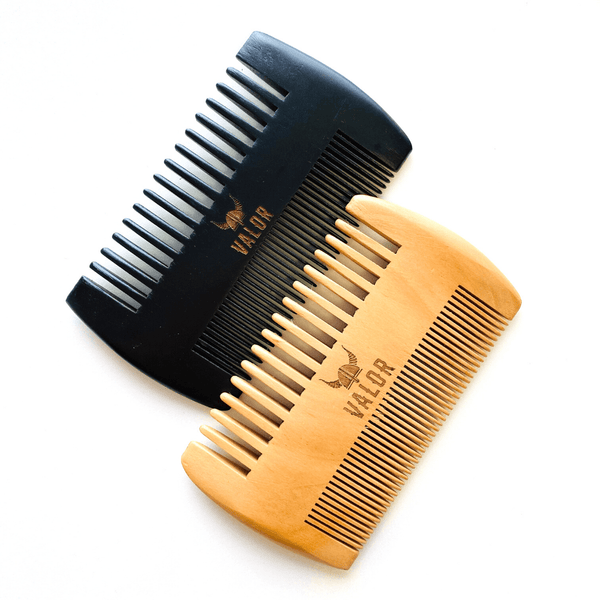 Image is of two cherry wood beard combs, one in natural finish and the other in black. Each comb has one side with wide-set teeth, and the other side has finer teeth. Photographed on a white background. 